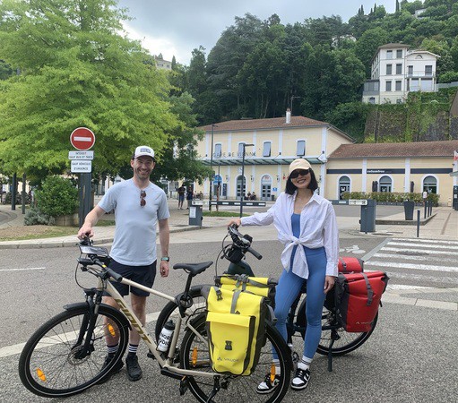 Image de deux personnes en train de faire une balade en velo VTC devant la gare de Vienne (38)
